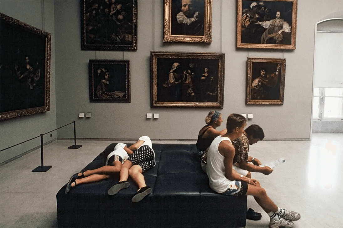 Visitors resting on a bench, fatigued from a museum visit